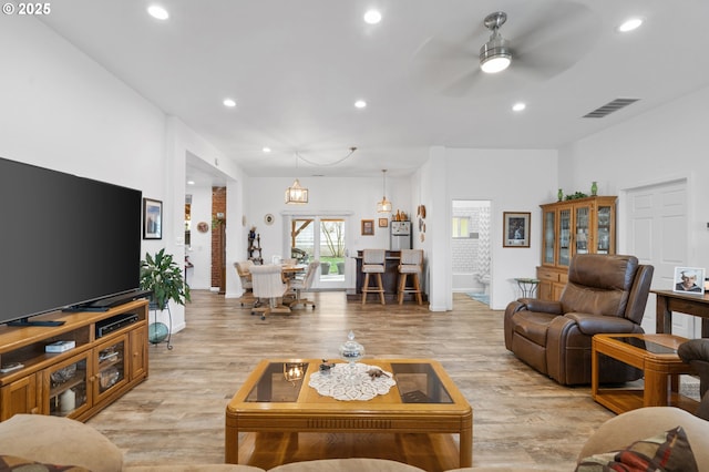 living room with light wood-style flooring, visible vents, ceiling fan, and recessed lighting