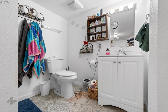 bathroom featuring toilet, baseboards, visible vents, and vanity