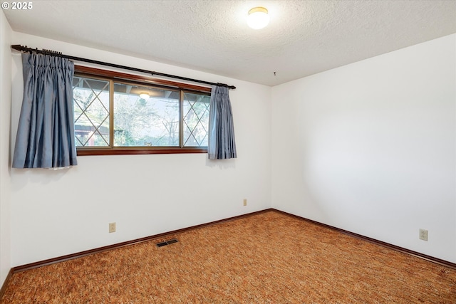 unfurnished room featuring a textured ceiling and carpet flooring