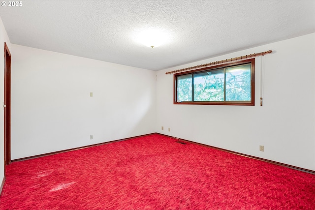 carpeted empty room with a textured ceiling