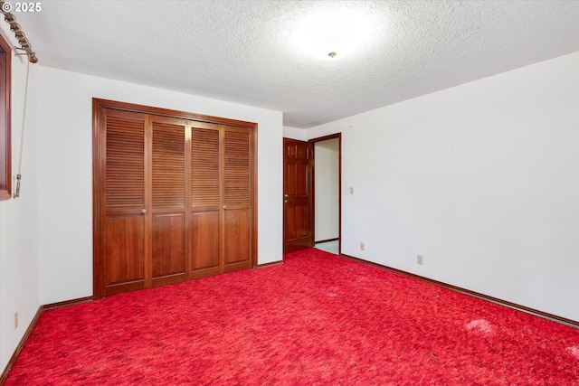 unfurnished bedroom with carpet floors, a textured ceiling, and a closet