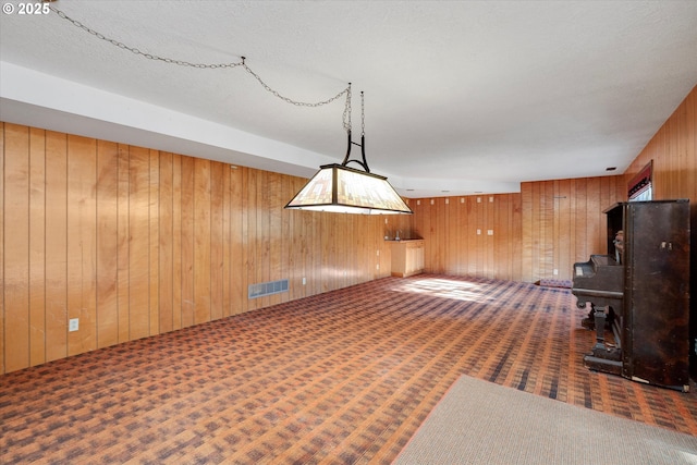 interior space with wood walls and dark carpet