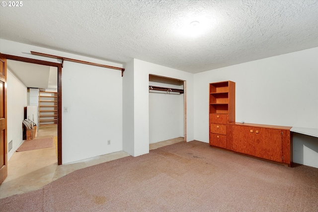 unfurnished bedroom with light colored carpet, a textured ceiling, and a closet