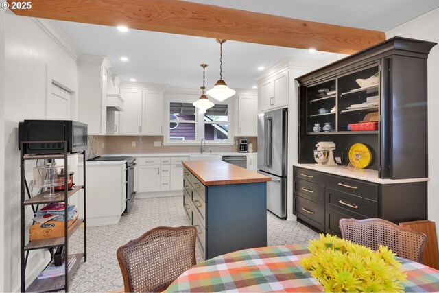 kitchen featuring wooden counters, appliances with stainless steel finishes, a center island, white cabinets, and recessed lighting