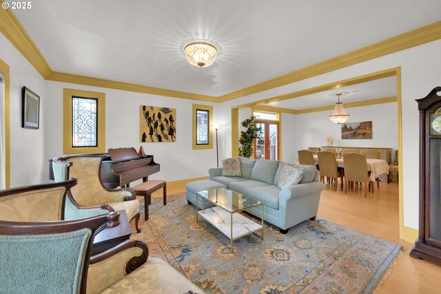 living room featuring crown molding, wood finished floors, and a wealth of natural light
