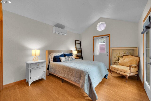 bedroom with an AC wall unit, baseboards, light wood finished floors, and lofted ceiling