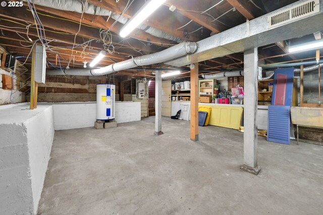 unfinished below grade area featuring water heater and visible vents