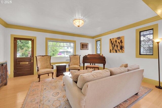living area with crown molding and light wood-style floors