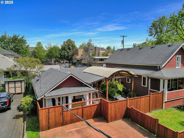 view of front of property featuring a gate, a fenced front yard, a residential view, and a shingled roof