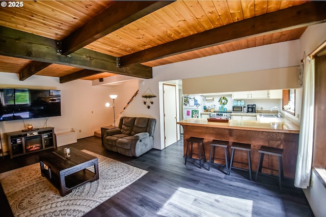 living area with dark wood-style floors, wooden ceiling, and beamed ceiling