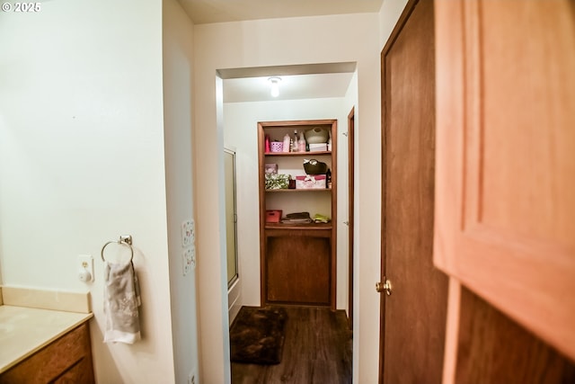 full bath with vanity, wood finished floors, a shower with door, and built in features