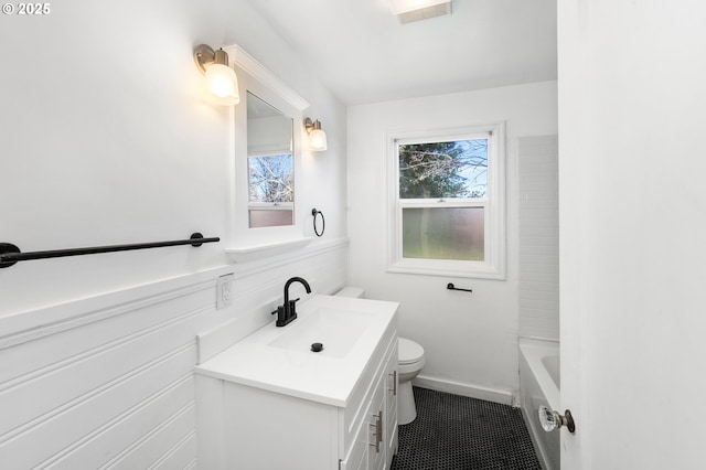 bathroom featuring tile patterned floors, toilet, vanity, and a bathing tub