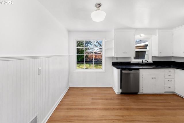 kitchen featuring sink, white cabinetry, stainless steel dishwasher, and light wood-type flooring