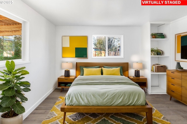 bedroom with hardwood / wood-style flooring and multiple windows