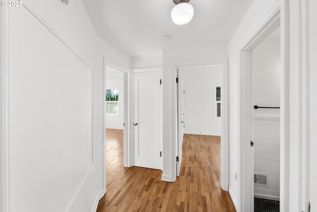 corridor with light hardwood / wood-style floors