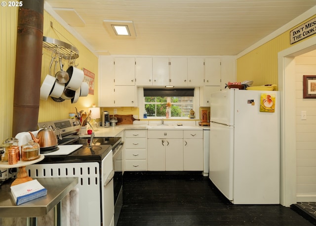 762 G St, Gearhart, OR 97138 - kitchen featuring white appliances, white cabinets, light countertops, wood walls, and dark wood finished floors