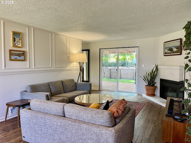 3851 Edgewood Dr, North Bend, OR 97459 - living room with a textured ceiling, baseboards, wood finished floors, and a fireplace