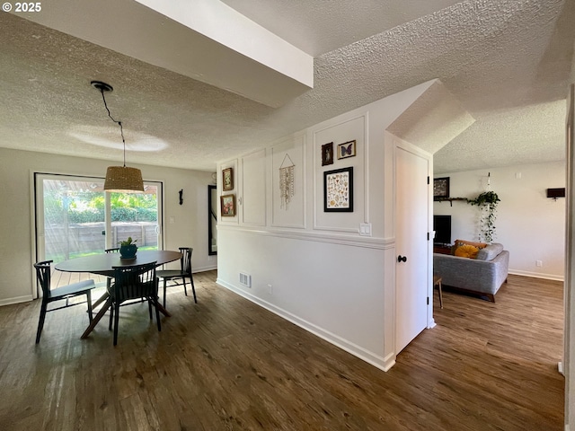 3851 Edgewood Dr, North Bend, OR 97459 - dining room featuring a textured ceiling, baseboards, and dark wood-style floors
