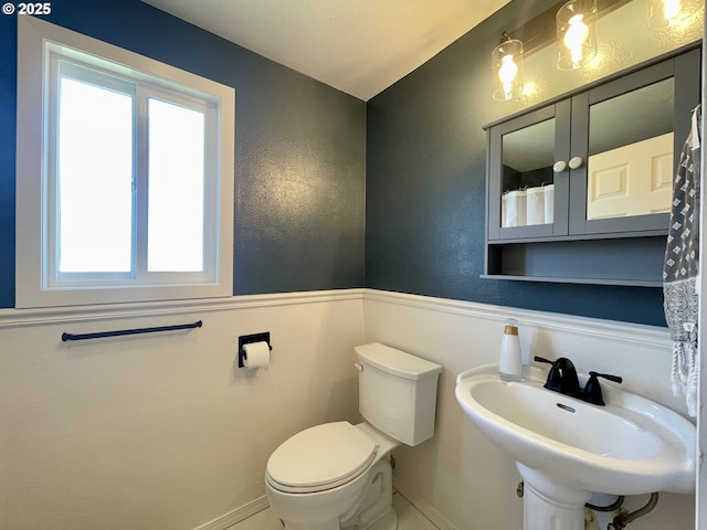 3851 Edgewood Dr, North Bend, OR 97459 - full bath featuring healthy amount of natural light, wainscoting, toilet, a sink, and curtained shower