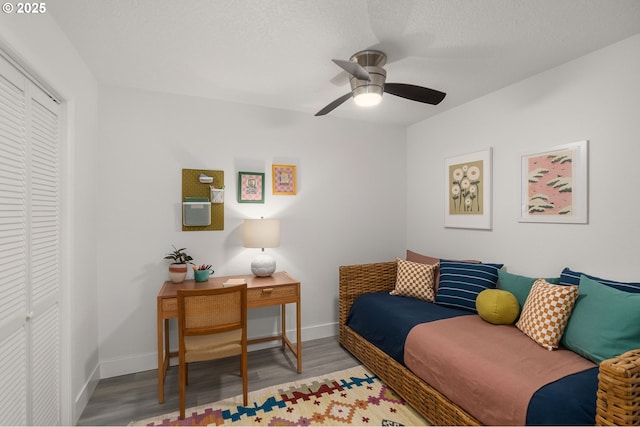 living room with baseboards, a ceiling fan, and wood finished floors