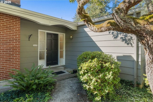 doorway to property with brick siding