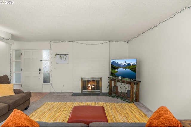 living room featuring a textured ceiling and a fireplace