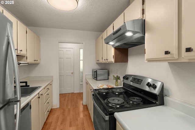 kitchen with under cabinet range hood, stainless steel appliances, light wood finished floors, and light countertops