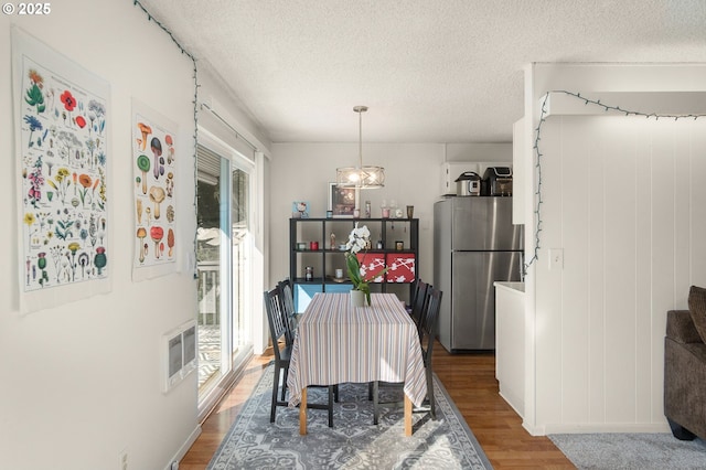 dining area featuring a textured ceiling and wood finished floors