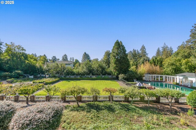 view of yard featuring fence and an outdoor pool