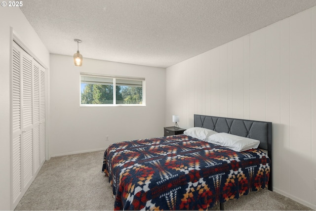 carpeted bedroom with a textured ceiling and a closet