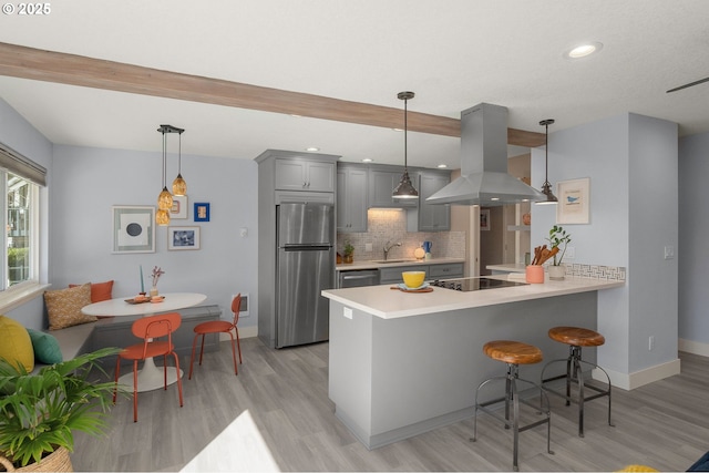 kitchen with a kitchen breakfast bar, light wood-style flooring, stainless steel appliances, island exhaust hood, and gray cabinetry
