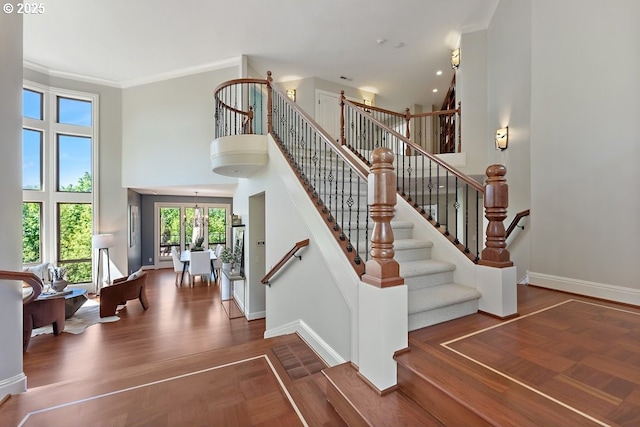 4055 NW Twilight Ter, Portland, OR 97229 - staircase featuring a towering ceiling, baseboards, crown molding, and wood finished floors