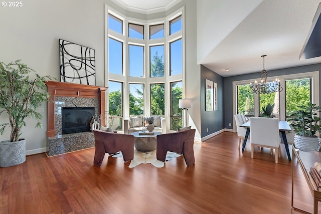 4055 NW Twilight Ter, Portland, OR 97229 - living area featuring a chandelier, baseboards, a high end fireplace, wood finished floors, and a high ceiling