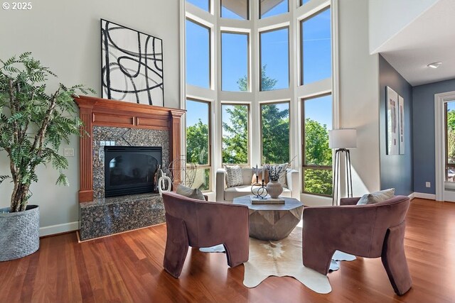 4055 NW Twilight Ter, Portland, OR 97229 - living area with baseboards, a premium fireplace, wood finished floors, and a towering ceiling