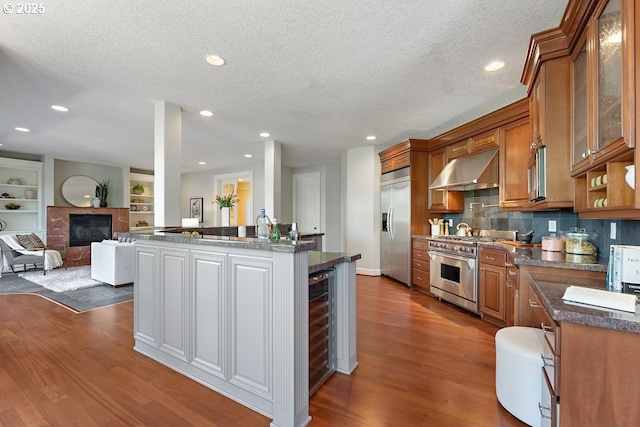 4055 NW Twilight Ter, Portland, OR 97229 - kitchen featuring exhaust hood, appliances with stainless steel finishes, dark wood-style flooring, a textured ceiling, and brown cabinets