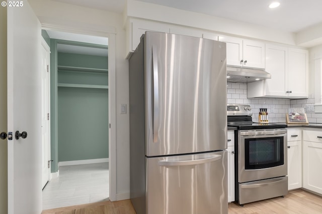 kitchen featuring stainless steel appliances, light hardwood / wood-style floors, decorative backsplash, and white cabinets