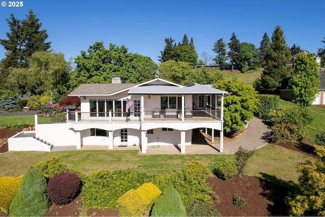 back of property featuring stairs, stucco siding, a chimney, a yard, and a patio area