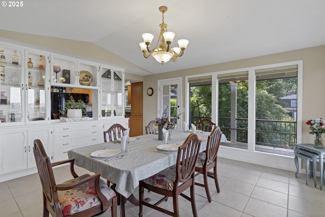 dining space featuring light tile patterned flooring, a notable chandelier, and lofted ceiling