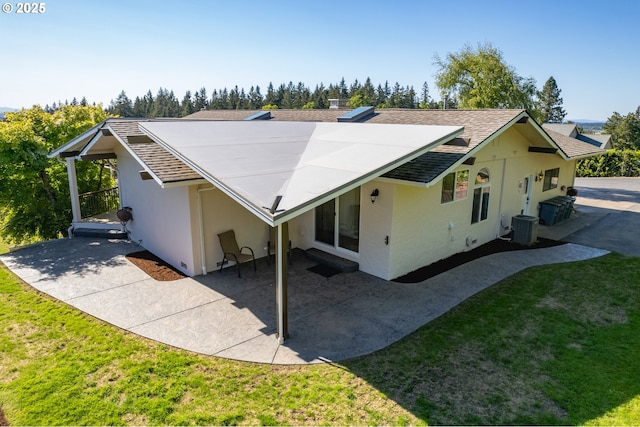 exterior space featuring an attached carport, stucco siding, a lawn, and a patio area