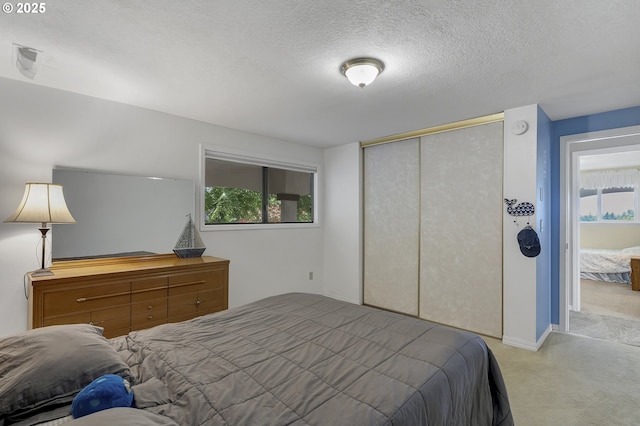 carpeted bedroom with a closet and a textured ceiling