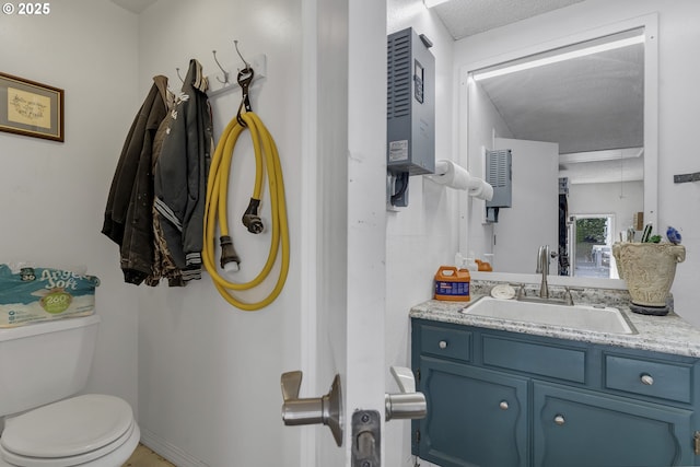 half bathroom featuring toilet, vanity, and baseboards