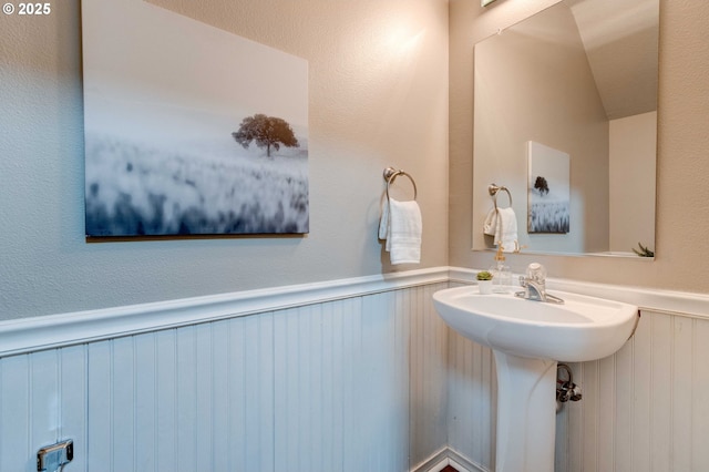 bathroom with a wainscoted wall