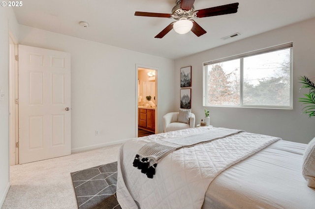 bedroom with visible vents, a ceiling fan, carpet flooring, ensuite bath, and baseboards