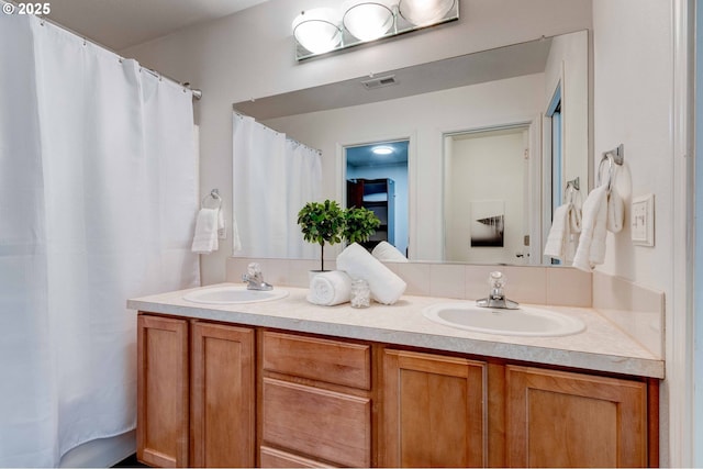 bathroom featuring double vanity, a sink, and visible vents