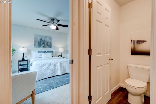 ensuite bathroom featuring baseboards, connected bathroom, toilet, ceiling fan, and wood finished floors