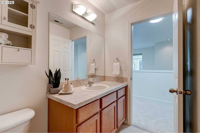 bathroom featuring toilet, visible vents, and vanity