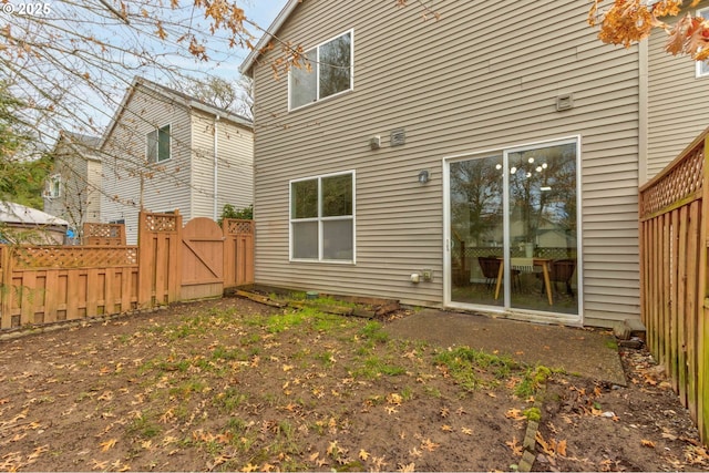 rear view of house with fence and a gate