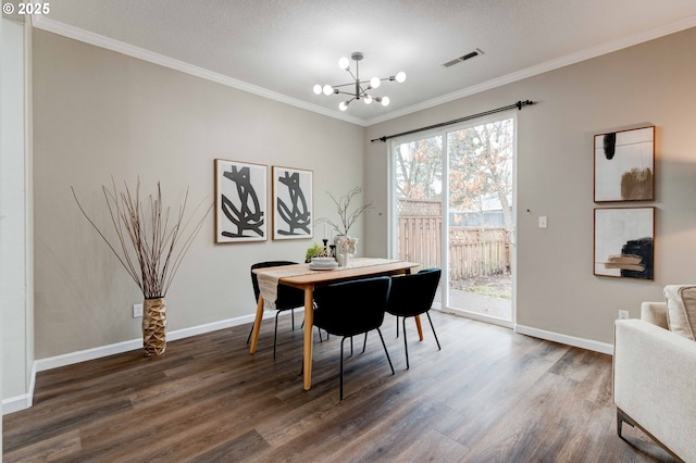 dining room with a notable chandelier, wood finished floors, visible vents, baseboards, and crown molding