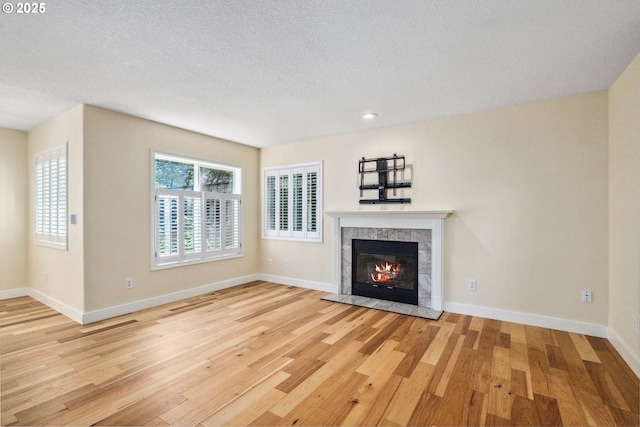 5364 Rosewood St, Lake Oswego, OR 97035 - unfurnished living room featuring wood finished floors, a tiled fireplace, a textured ceiling, baseboards, and recessed lighting