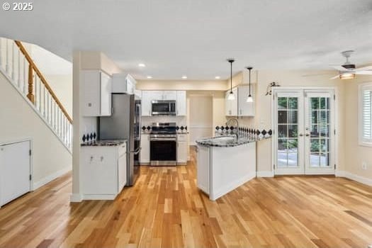 5364 Rosewood St, Lake Oswego, OR 97035 - kitchen with appliances with stainless steel finishes, white cabinetry, light wood-type flooring, a peninsula, and recessed lighting